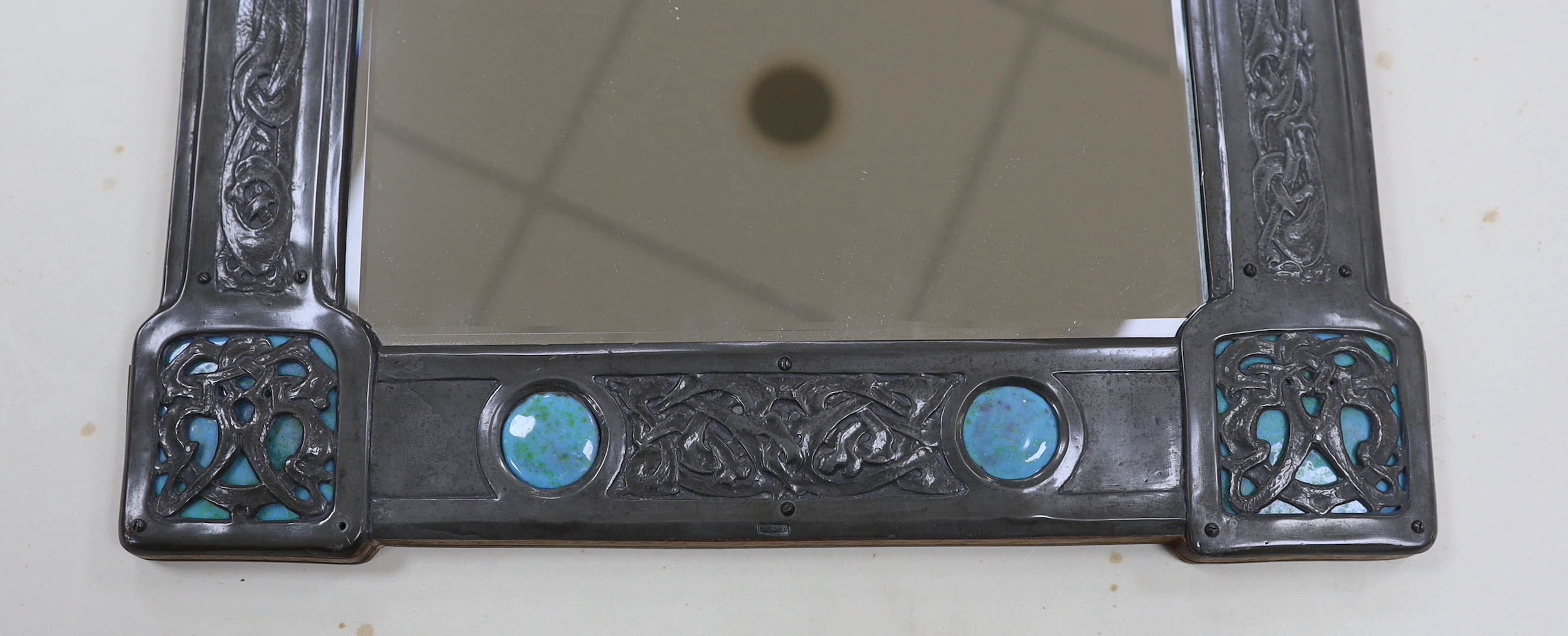 A Miller Brothers Art Nouveau embossed pewter mirror with cabochon turquoise enamel bosses, 48cm high x 39cm wide